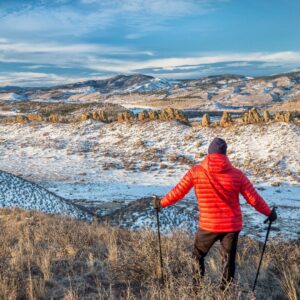 A hiker with walking sticks looking at winter scene